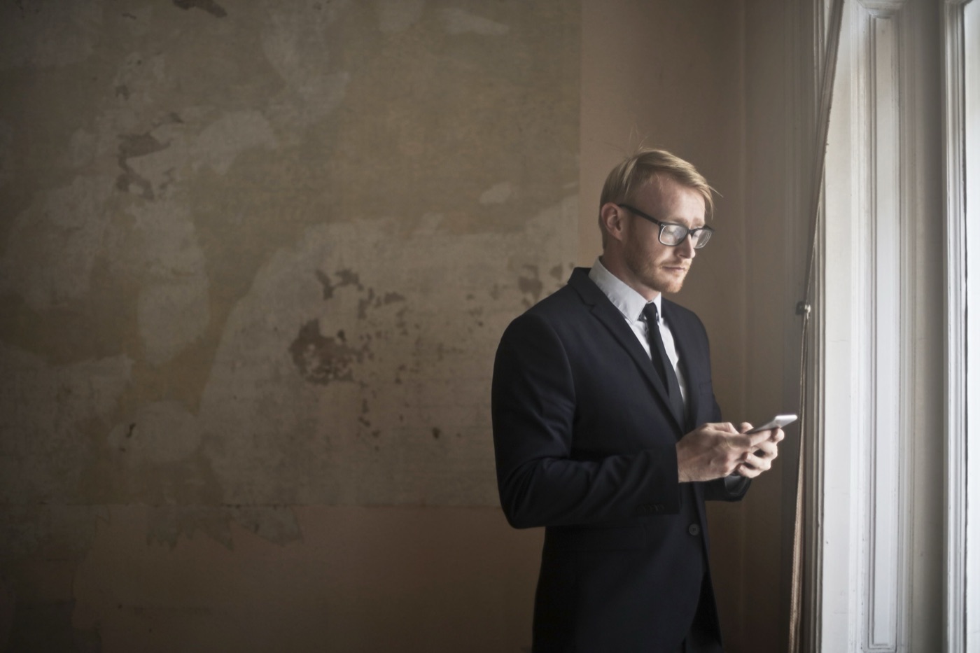 A man standing alone in a quiet room, the tension of an unresolved conversation still in the air.