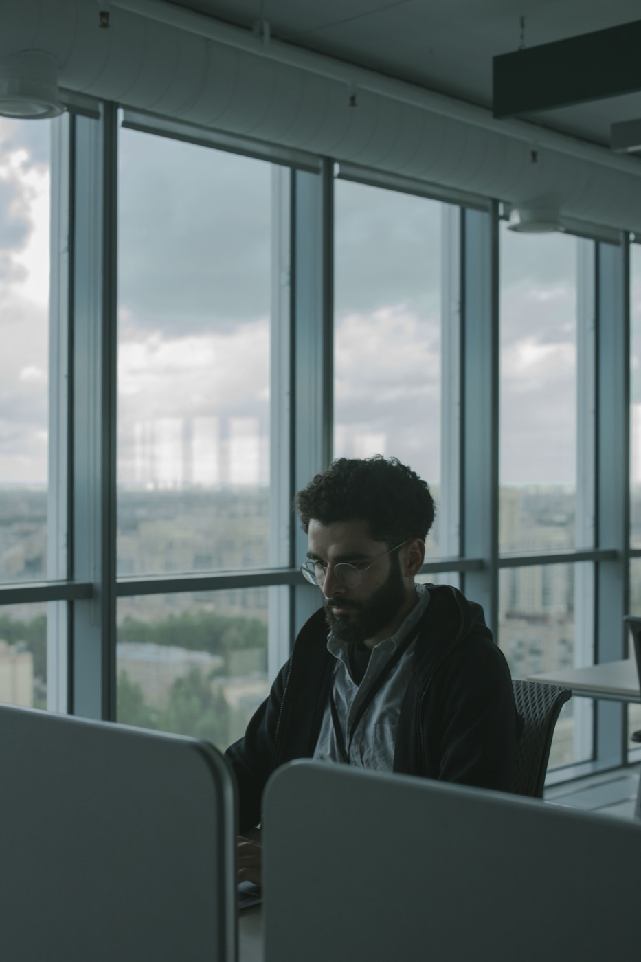 A successful man alone in his office, present in the room but somewhere else entirely.
